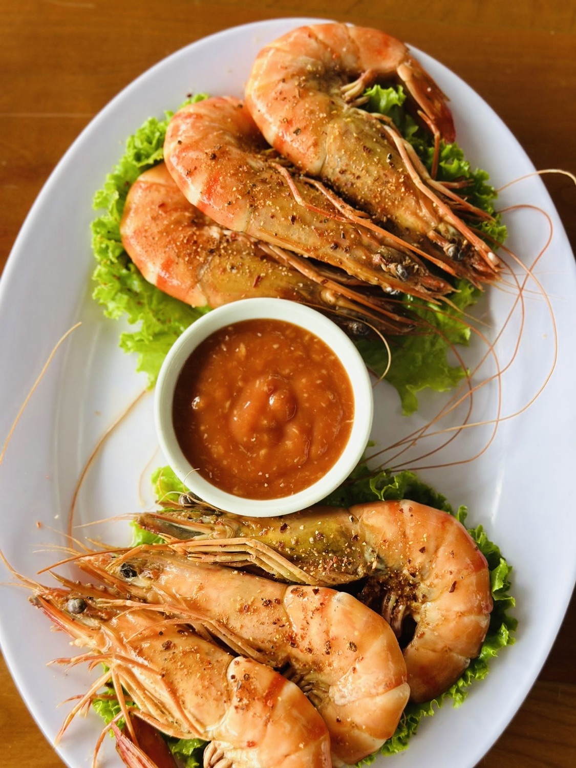 Cooked prawns with lettuce and dipping sauce.